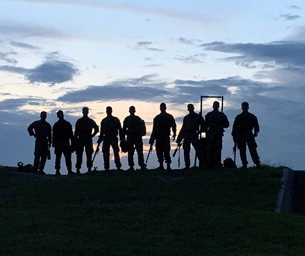 Strikeline athletes silhouetted on a hill at dusk